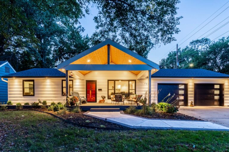 Wide shot of a home with lights on at night after home exterior design in Overland Park