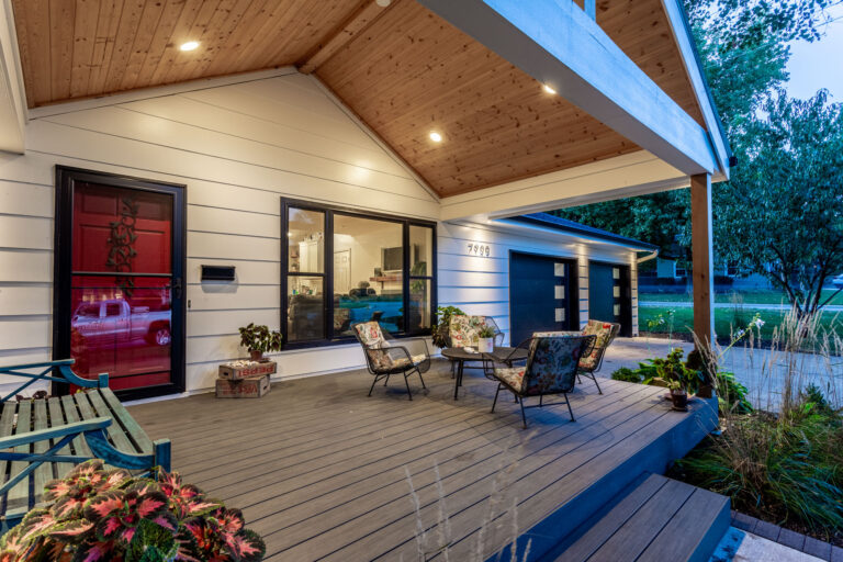 Close up of a home's front porch with lights on at night after a deck renovation in Overland Park