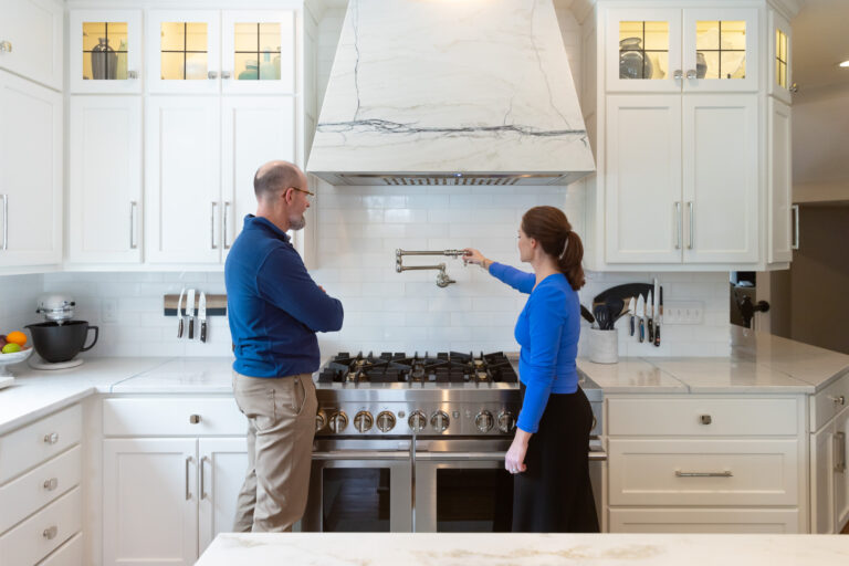 A contractor shows a female client her new kitchen after completing a home improvement in Overland Park