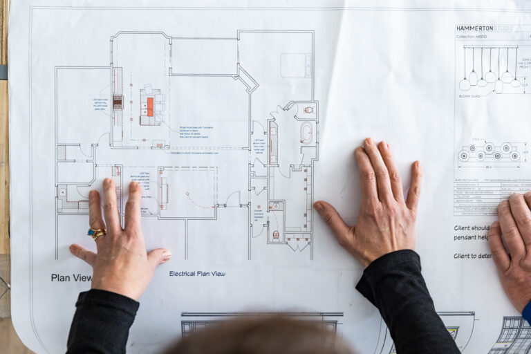 An overhead shot of a designer looking at blueprints for home interior renovations in Overland Park