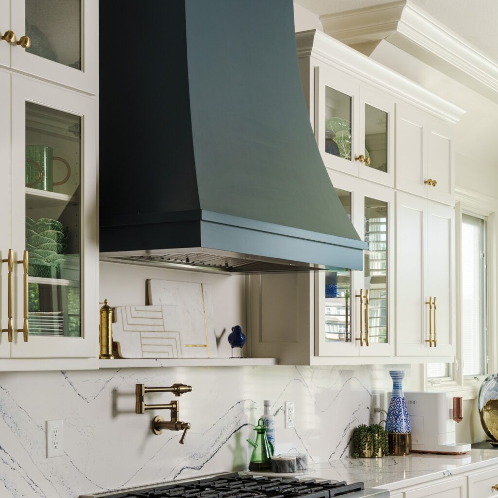 a custom range hood and floating marble shelf featured in a remodeled kitchen that was part of an early 2000s home update