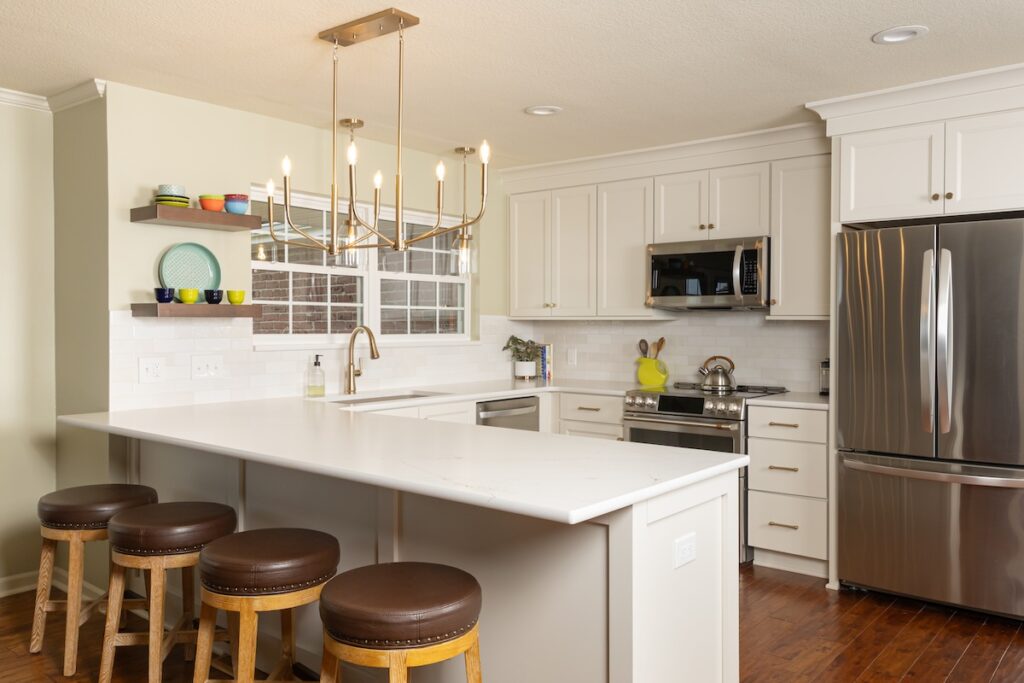 A wide view of a recent kitchen makeover in Overland Park that includes refreshed bar stools, custom-fit countertops, and curated fixtures for a cohesive, modern look.